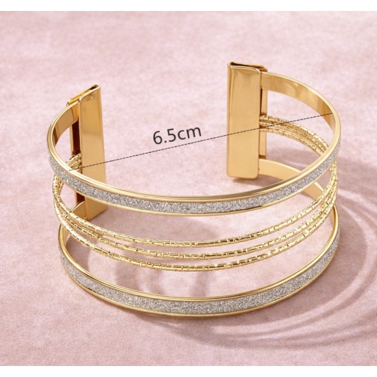 Bransoletka mankietowa w kolorze złotym.